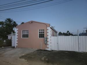 een roze huis naast een wit hek bij El Palacio Hidden City Place #2 in Bridgetown
