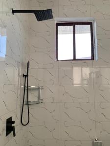 a shower in a bathroom with a window at Nungwi holiday apartments in Nungwi