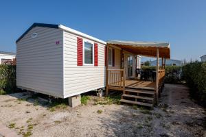 a small white tiny house with a porch at Mobil home Cécile in Fréjus