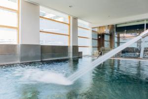 a water hose is spraying water into a swimming pool at Axis Porto Business & Spa Hotel in Porto