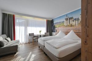 フュッセンにあるHotel Ruchti - Zeit für michのベッド2台とテーブルがあるホテルの部屋 +125枚の写真