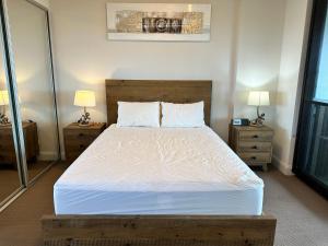 a bedroom with a large bed with two night stands at Best location apartment in Olympic park in Sydney