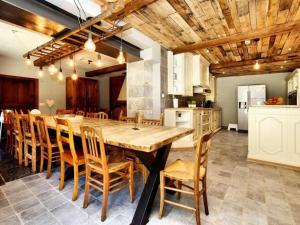 eine große Küche mit einem großen Holztisch und Stühlen in der Unterkunft La Conciergerie in Beauraing