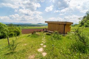 un banco sentado en la cima de una colina con un campo en Hviezdna noc, en Spišský Hrhov