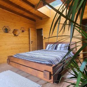 uma cama num quarto com uma parede de madeira em Hviezdna noc em Spišský Hrhov