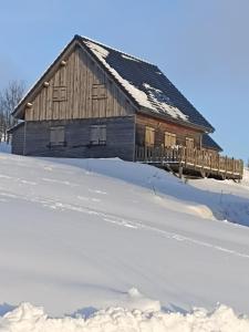 un antiguo granero en un campo cubierto de nieve en Chalet des Monts Dore, en Chastreix