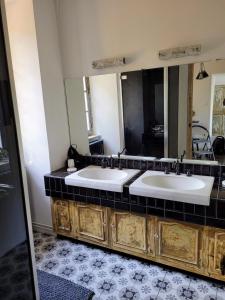 a bathroom with two sinks and a large mirror at LE MANOIR PARADI in Presles-et-Thierny