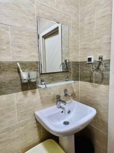 een badkamer met een wastafel en een spiegel bij Comfort apartment in Tasjkent