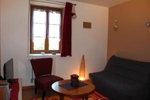 sala de estar con sofá, mesa y ventana en Gîte Savauldetour, en Ouroux