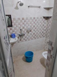 a bathroom with a toilet and a sink and a bucket at Budha ashram guest house in Bodh Gaya