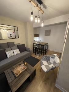 a living room with a couch and a table at Le Charmant Paillot Hyper Centre classé in Troyes +15 photos