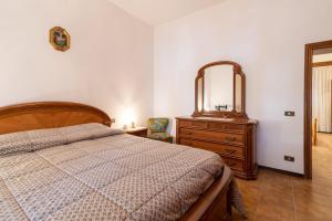 um quarto com uma cama, uma cómoda e um espelho em Le Balze nel cuore della Toscana em Castelfranco di Sopra