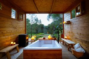 a bath tub sitting inside of a wooden cabin at Kampaoh Córdoba in Córdoba