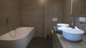 uma casa de banho com uma banheira e um lavatório e uma banheira em Jeux de Goûts em Hérissart