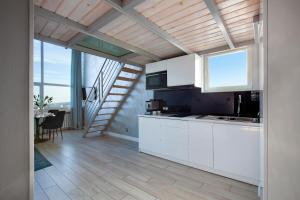 a kitchen with white cabinets and a staircase at Panorama- the View of Gdańsk by Elite Apartments in Gdańsk