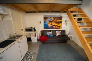 a living room with a couch and a staircase at Ilha D'ouro House S. Vitor II in Porto