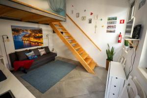 ein Wohnzimmer mit einem Sofa und einer Treppe in der Unterkunft Ilha D'ouro House S. Vitor II in Porto