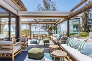 un salón acristalado con sofás, mesas y ventanas en Lagoon Attitude (Adults Only) en Cap Malheureux