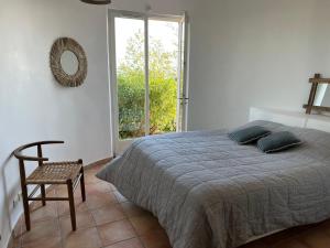 sypialnia z łóżkiem, krzesłem i oknem w obiekcie LUXUEUSE VILLA, INCROYABLE VUE MER, PISCINE w miejscowości Sainte-Maxime