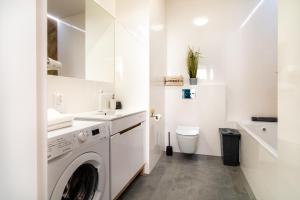 拉多姆的住宿－ApartamentySnu, Jagielloński Komfort, Centrum，白色的浴室设有洗衣机和卫生间。