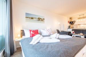 um quarto com uma cama com almofadas vermelhas e brancas em Hanseatenhaus Whg 79 Kramp em Westerland
