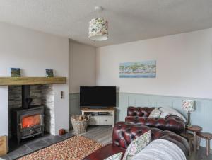 a living room with a couch and a fireplace at 1 Bronrallt in Conwy