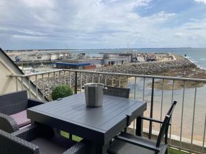 una mesa en un balcón con vistas a la playa en L'appartement entre ciel et mer, en La Turballe