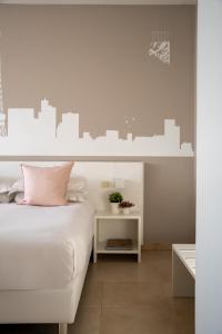 1 dormitorio con cama blanca y pared de la ciudad en Castello D'Argile Hotel, en Castello dʼArgile