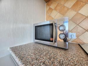 un forno a microonde seduto su un bancone in una stanza di Le Green - Appt Houlgate vue sur le golf a Houlgate