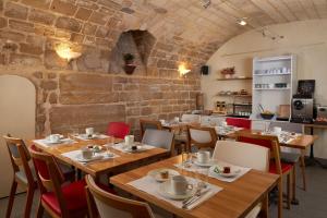 a restaurant with wooden tables and chairs and a brick wall at Grand Hôtel Malher in Paris