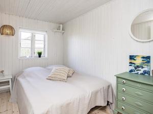 Holiday home Kerteminde XII في كيرتيمايند: غرفة نوم بيضاء بها سرير ونافذة