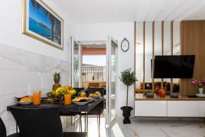 a dining room with a table with fruit on it at Apartment Rose Pool Comfort in Dubrovnik