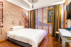 a bedroom with a large bed and a desk at Puzzle Hotel - Zhongshan 8th Road Chenjiaci Subway Station Branch in Guangzhou
