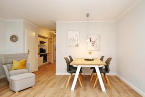 a dining room and living room with a table and chairs at Papillon Wohnung 03-3 in Boltenhagen