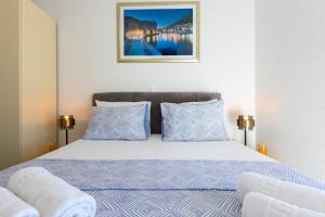 a bedroom with a bed with blue and white pillows at Apartment Rose Pool Comfort in Dubrovnik +38 photos
