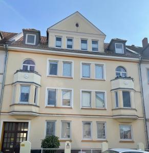 un grande edificio giallo con un orologio sopra di Attraktive 2 Zimmer Wohnung in Toplage, Nähe Messe ad Hannover