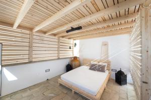een slaapkamer met een bed en een houten plafond bij Casa Harem in Taurisano