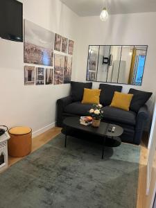 a living room with a couch and a coffee table at EXPOSITION APPARTEMENT in Paris