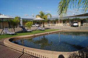 a swimming pool in a yard next to a building at Belltower Motor Inn in Shepparton