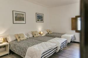 2 łóżka w pokoju z białymi ścianami w obiekcie Can Picola w mieście Capmany