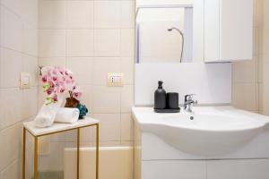 a white bathroom with a sink and a mirror at Dimora a Palazzo in Monopoli