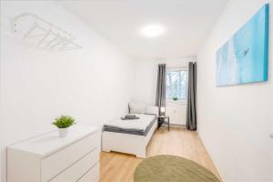 Cette chambre blanche dispose d'un lit et d'une fenêtre. dans l'établissement Modern Apartment near Bottrop, à Gladbeck