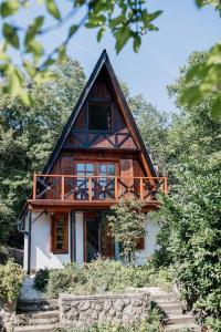 ein Holzhaus mit Balkon darüber in der Unterkunft Erdő Lelke Vendégház: mesebeli, erdőszéli faház panorámával in Nagymaros