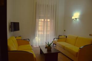 a living room with two yellow couches and a table at Hospedium Palacio del Gobernador in Moral de Calatrava
