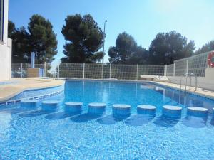 a large swimming pool with stools in the water at Patios I in Peniscola