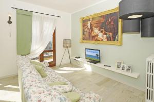 - un salon avec un canapé et une télévision dans l'établissement Le Fontane Lux - Gardagate, à Roe