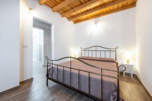 1 dormitorio con 1 cama en una habitación con paredes blancas en Casa Giovanna, en San Giovanni Suergiu