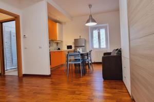 uma sala de estar com uma cozinha e uma mesa e cadeiras em My House&Apartments em Agrate Brianza