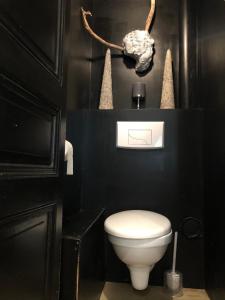 a bathroom with a toilet and a black wall at L’atelier de Graslin in Nantes