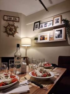 a table with plates of food and a bottle of wine at Seascape Villas Kinira - Elia & Anatoli in Kinira